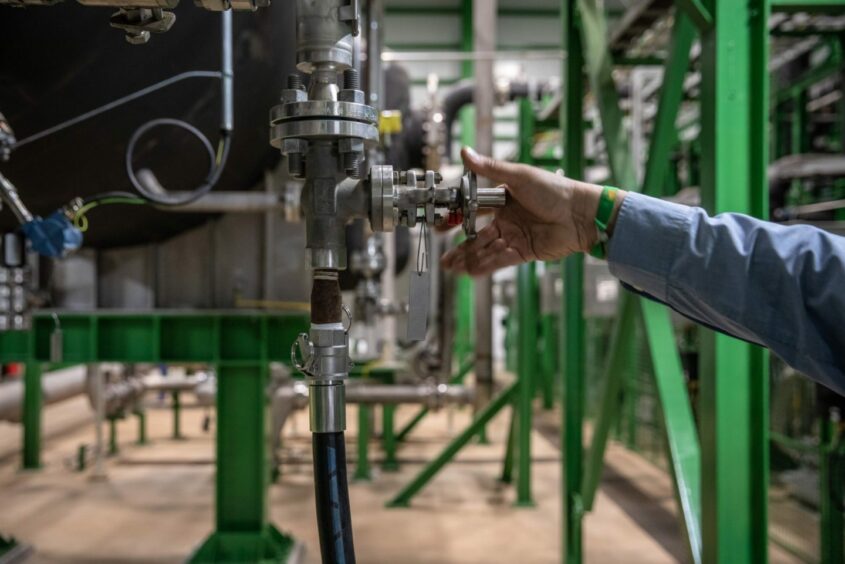 A worker adjusts a valve wheel inside the electrolyzer area during the final stages of construction at Iberdola SA's Puertollano green hydrogen plant in Puertollano, Spain, on Thursday, May 19, 2022. The new plant will be Europe's largest production site for green hydrogen for industrial use. Photographer: Angel Garcia/Bloomberg