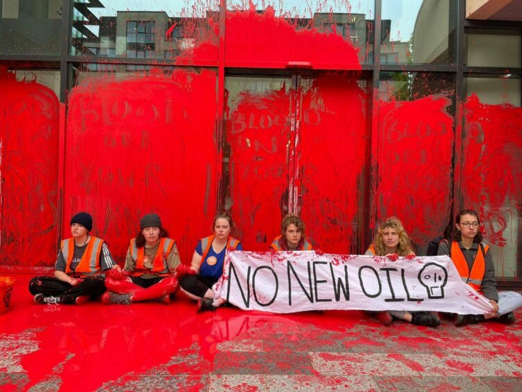 Just Stop Oil protestors cover the entrance of Queen Elizabeth House in red paint.