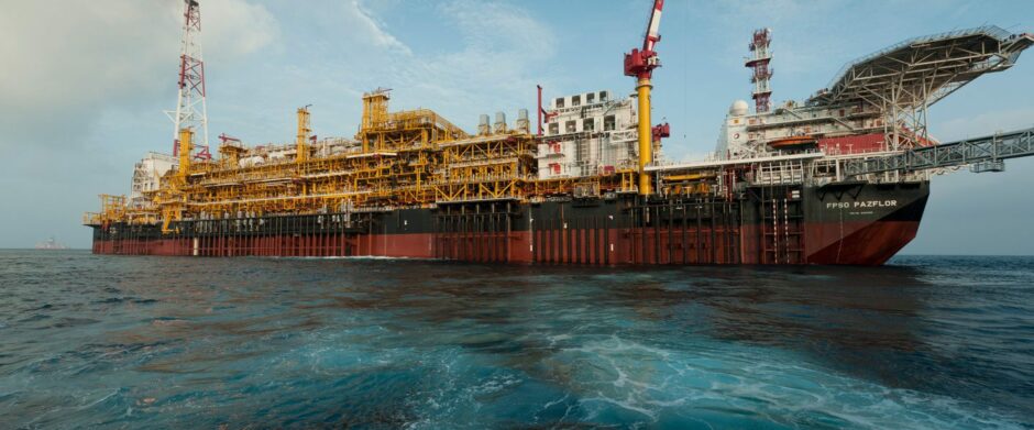 Red and black FPSO in light blue water