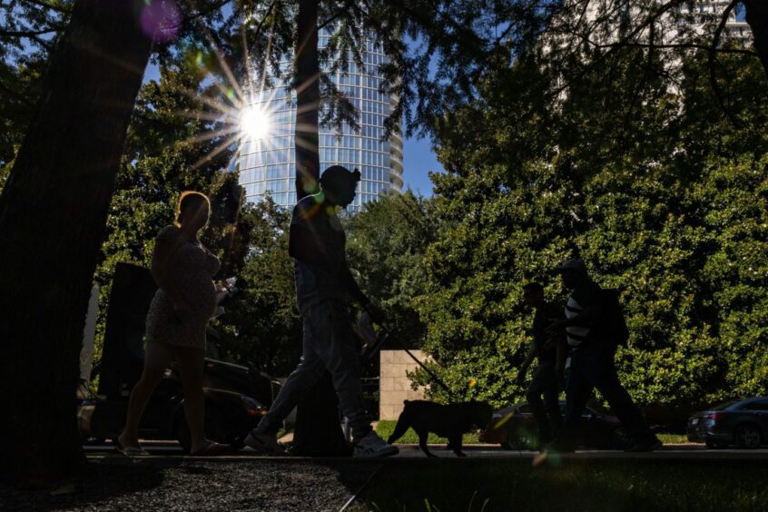 Pedestrians walk along a street during a heatwave in Dallas, Texas, US, on Tuesday, June 21, 2022. Photographer: Shelby Tauber/Bloomberg