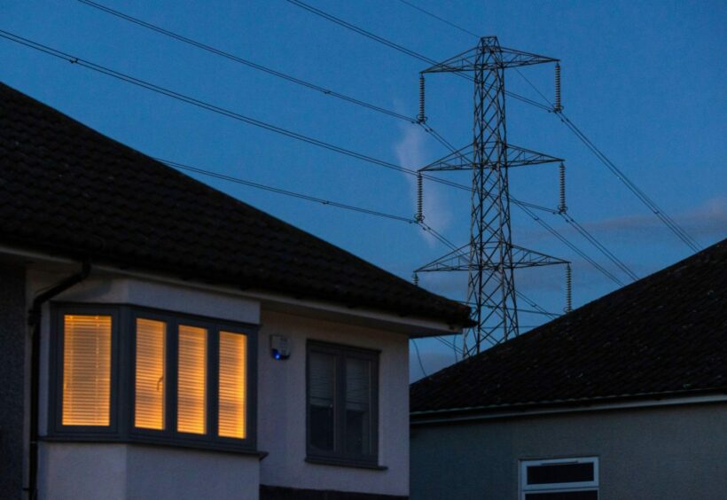 A light on at a residential home near an electricity transmission tower in Upminster, UK.