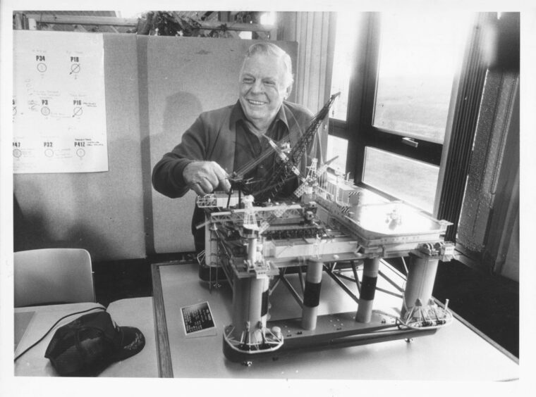 Red Adair with a model of the Tharos during a press conference in Aberdeen.