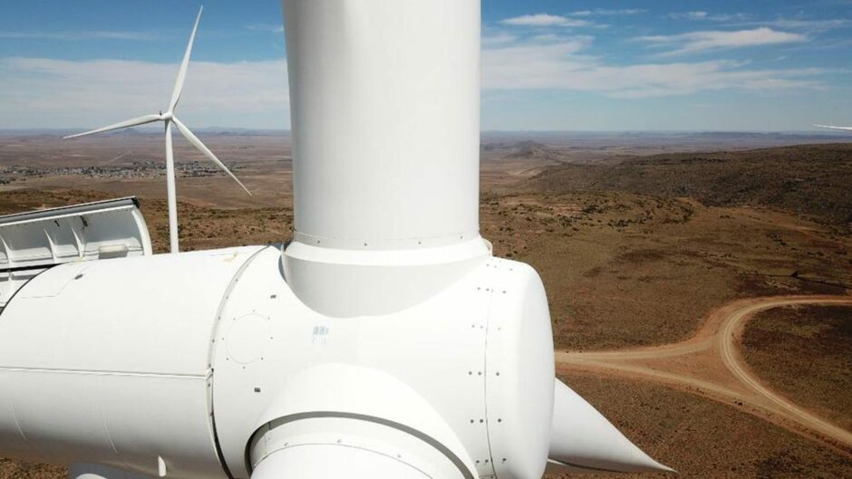 Close up of wind turbine with hot landscape behind