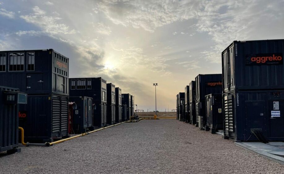 Sunset with generators on each side of a sand road