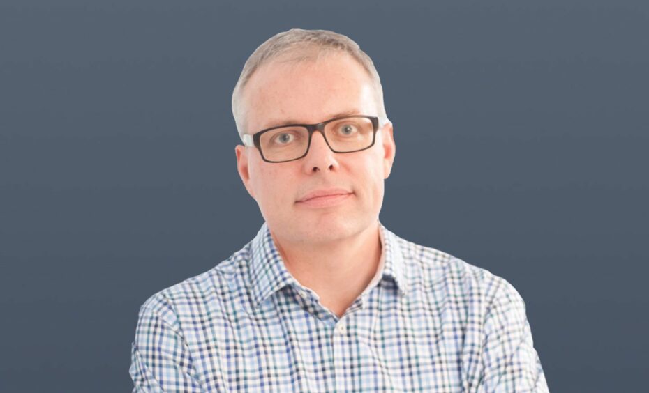 Head shot of man with glasses against grey background