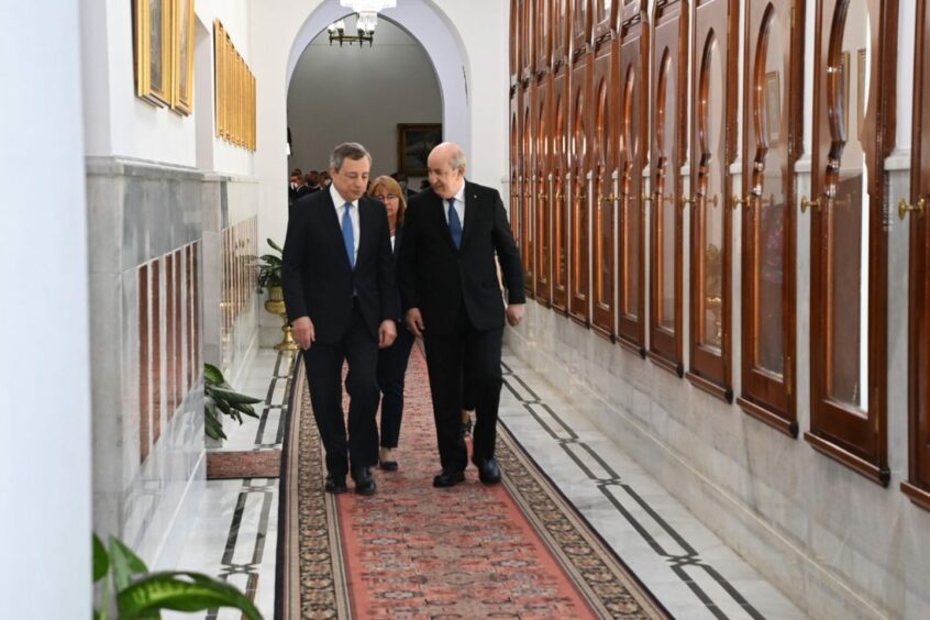 Two men walk down corridor