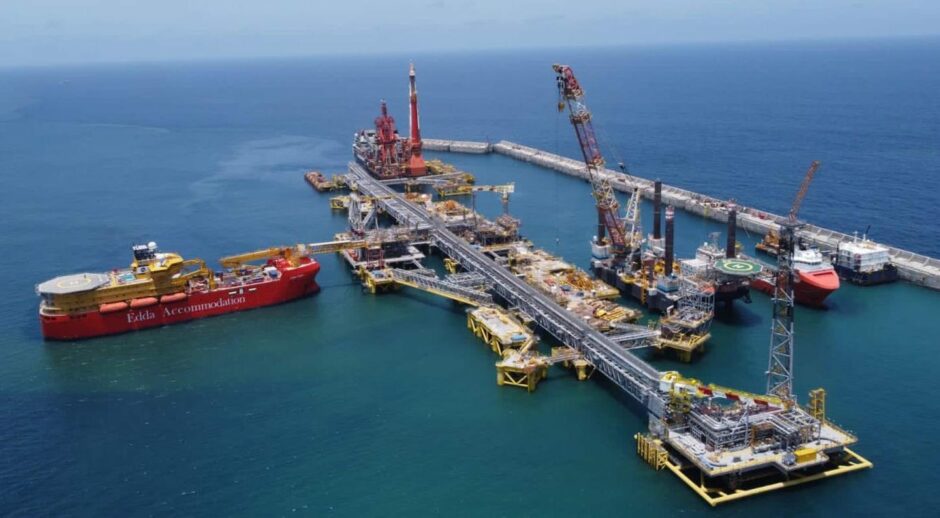 Red accommodation ship docked at floating facility