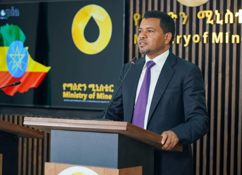 Man in suit stands at podium