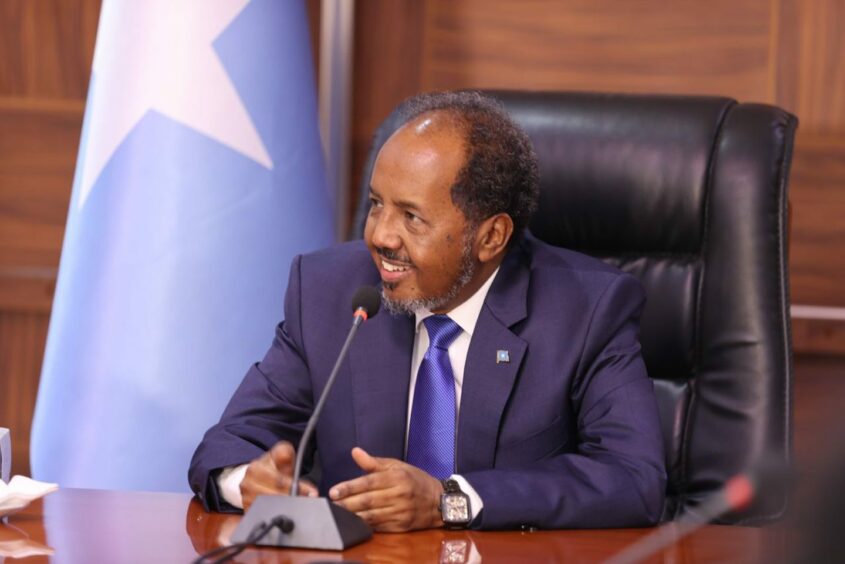Man sits at table next to Somali flag
