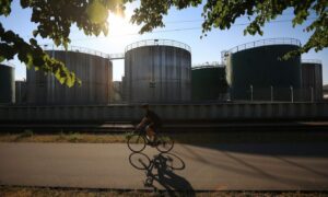 Bicyclist in front of oil storage tanks