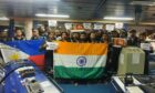 Group of men hold Indian flag in a control room