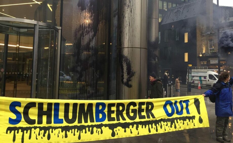 Yellow banner with oil saying "Schlumberger out"