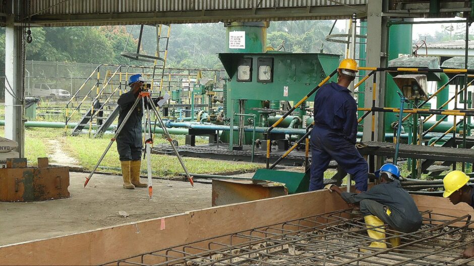 Workers in blue overalls carryout industrial construction