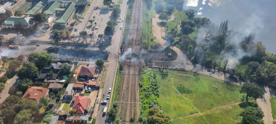 Aerial shot of rail line and bridge, with smoke