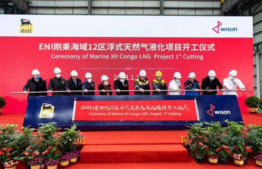 People in hard hats in front of red backdrop