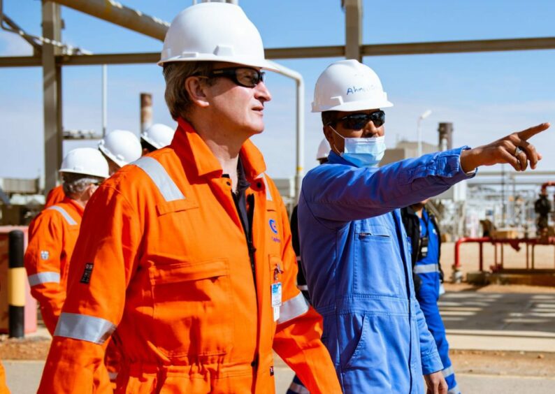 Man in orange suit and man in blue suit pointing