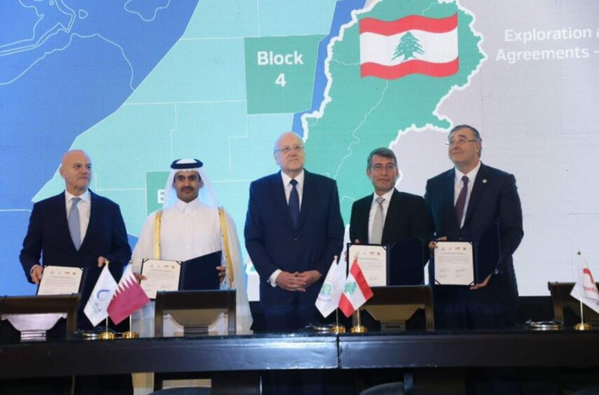 Men hold documents in front of map back drop