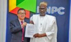 Two men hold document in front of NNPC backdrop