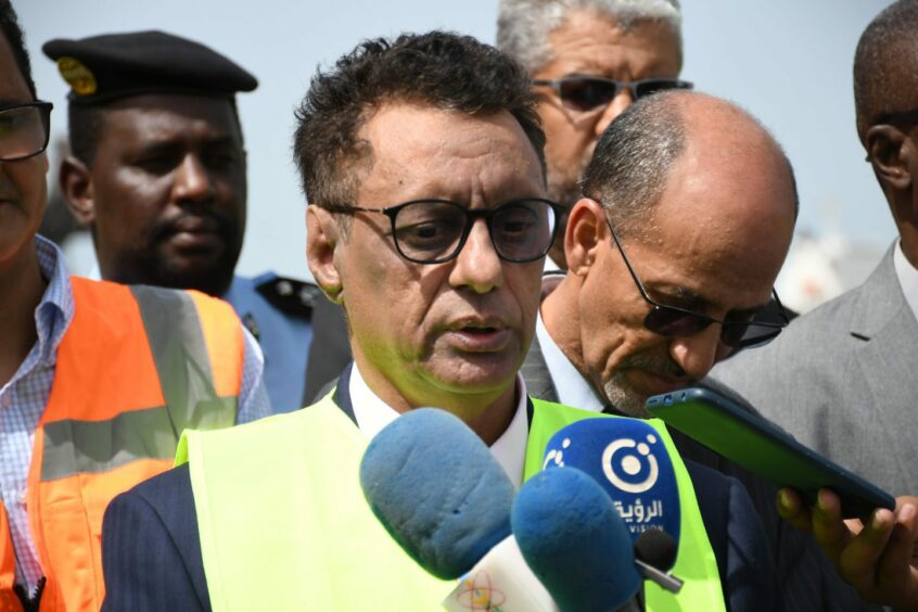 Man in hi vis vest speaks into mic