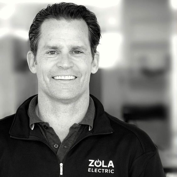 Black and white headshot of man with Zola branded jumper