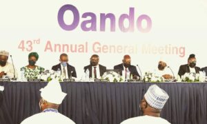 Oando backdrop, with people sitting on a stage