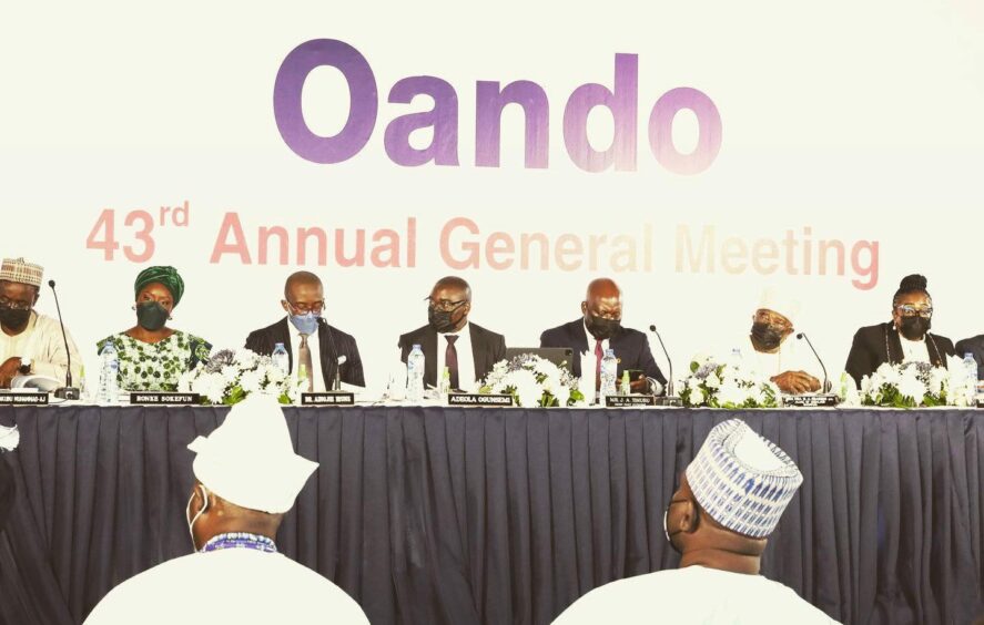 Oando backdrop, with people sitting on a stage