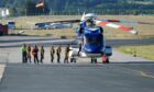 Offshore workers board a Bond helicopter at Aberdeen International Airport.