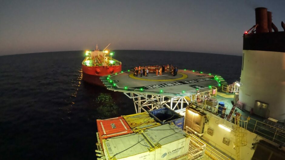 Dawn on an FPSO, a group gathers on the helideck