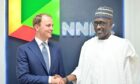 Two men shake hands in front of NNPC backdrop
