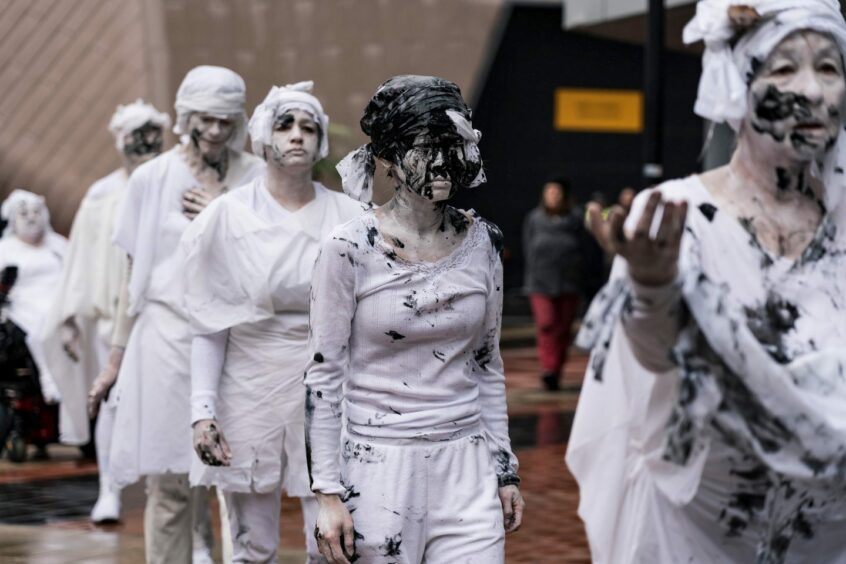 Activists dressed in white outside the APPEA conference in Adelaide