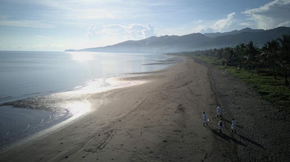 Fishery workers cleaning a beach after an oil spill prevented them from making a living in the Philippines