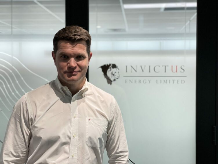 Invictus MD Scott Macmillan in front of Invictus logo