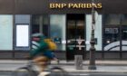 A cyclist passes a BNP Paribas SA bank branch in the Opera district of Paris, France, on Monday, Feb. 6, 2023.