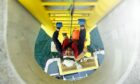 A worker ascending an offshore wind turbine.