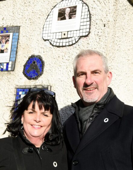 Steve and MaryAnn in front of his plaque on Aberdeen's Everyday Heroes mural in the city centre.