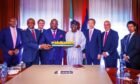 UTM's Julius Rone and President Tinubu hold a model of an FLNG vessel