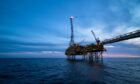 An oil rig silhouetted against a night sky