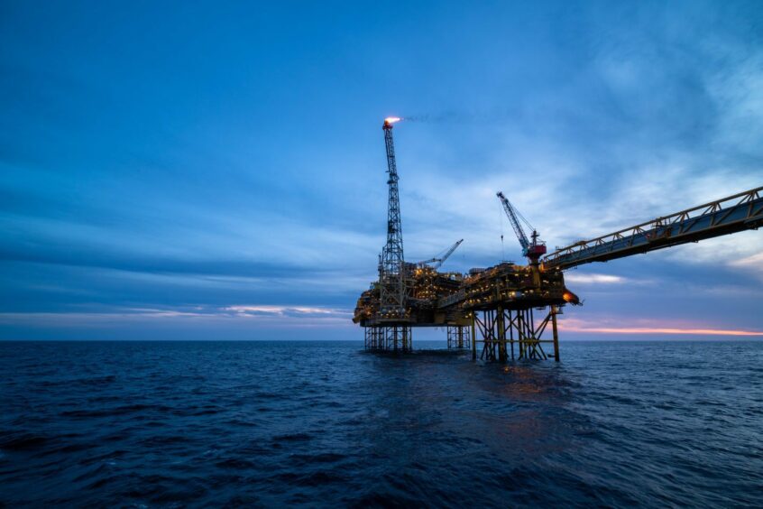 An oil rig silhouetted against a night sky