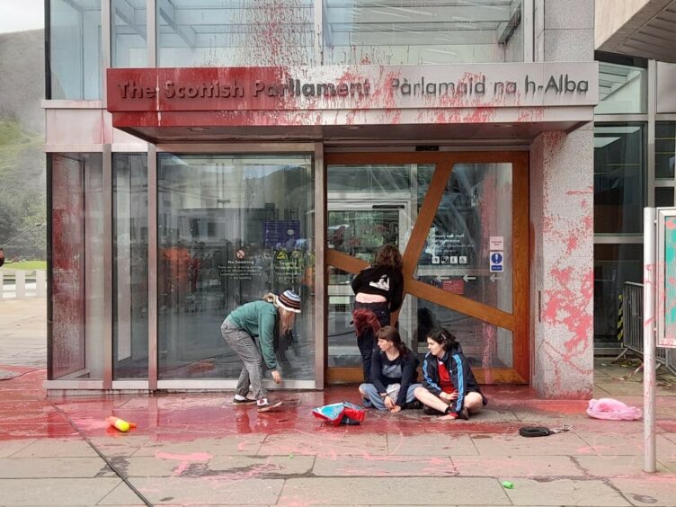 Protestors spray red paint over the entrance to Holyrood.