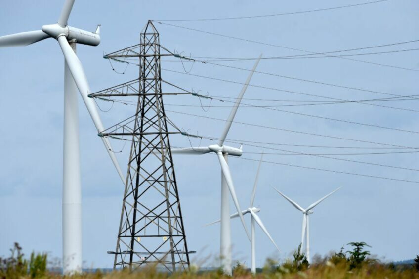 Wind turbines and electricity pylons carrying their electricity on the Causeymire in Caithness..