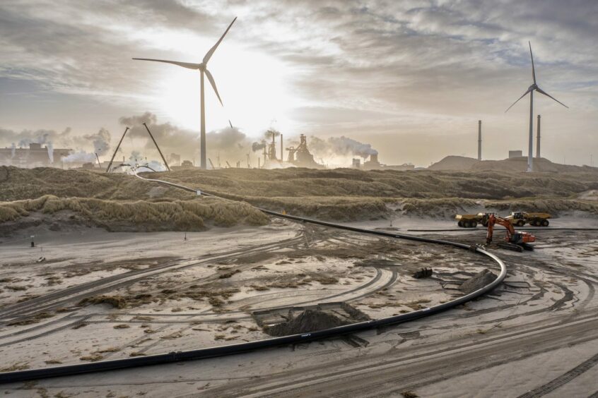 Digging for transmission infrastructure on the beach at Heemskerk.. Netherlands.