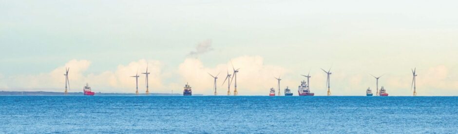 wide shot of wind turbines in the middle of the sea