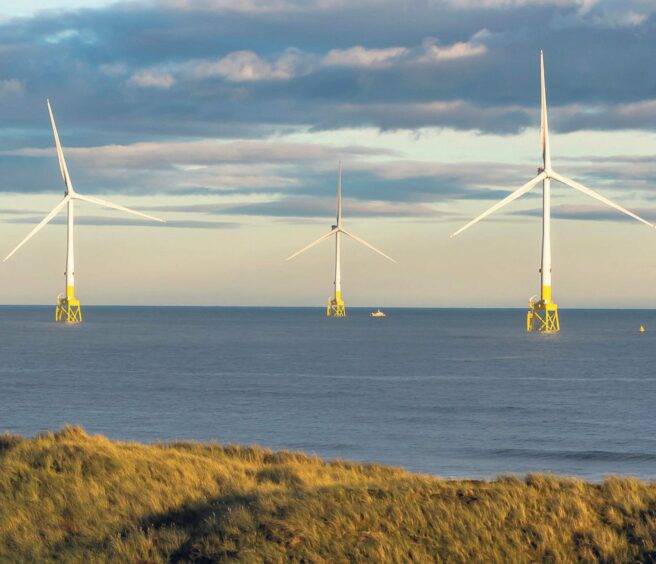 three wind turbines in the middle of the sea