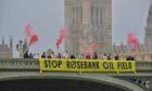 Fossil Free London Activists unveil a Stop Rosebank banner on Westminster Bridge in 2023.