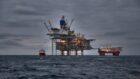 Picture of offshore oil and gas production in the sea in stormy weather at dusk.