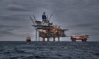 Picture of offshore oil and gas production in the sea in stormy weather at dusk.