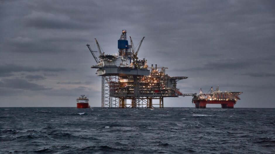 Picture of offshore oil and gas production in the sea in stormy weather at dusk.