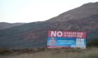 Billboards on the Cowal peninsula against the Ardtaraig Wind Farm in 2018.