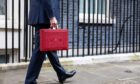 The Chancellor Jeremy Hunt walks outside Downing Street with the Budget box. Supplied by Zara Farrar / HM Treasury