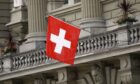 Swiss national flag fly outside the Federal Palace, Switzerland's parliament building, in Bern, Switzerland, on Wednesday, June 6, 2018. Photographer: Stefan Wermuth/Bloomberg